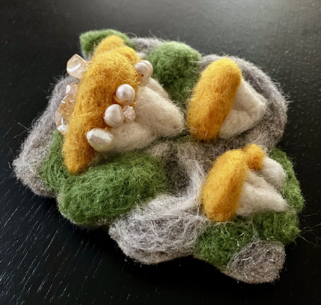 Needlefelted mushrooms with pearls sewn on.