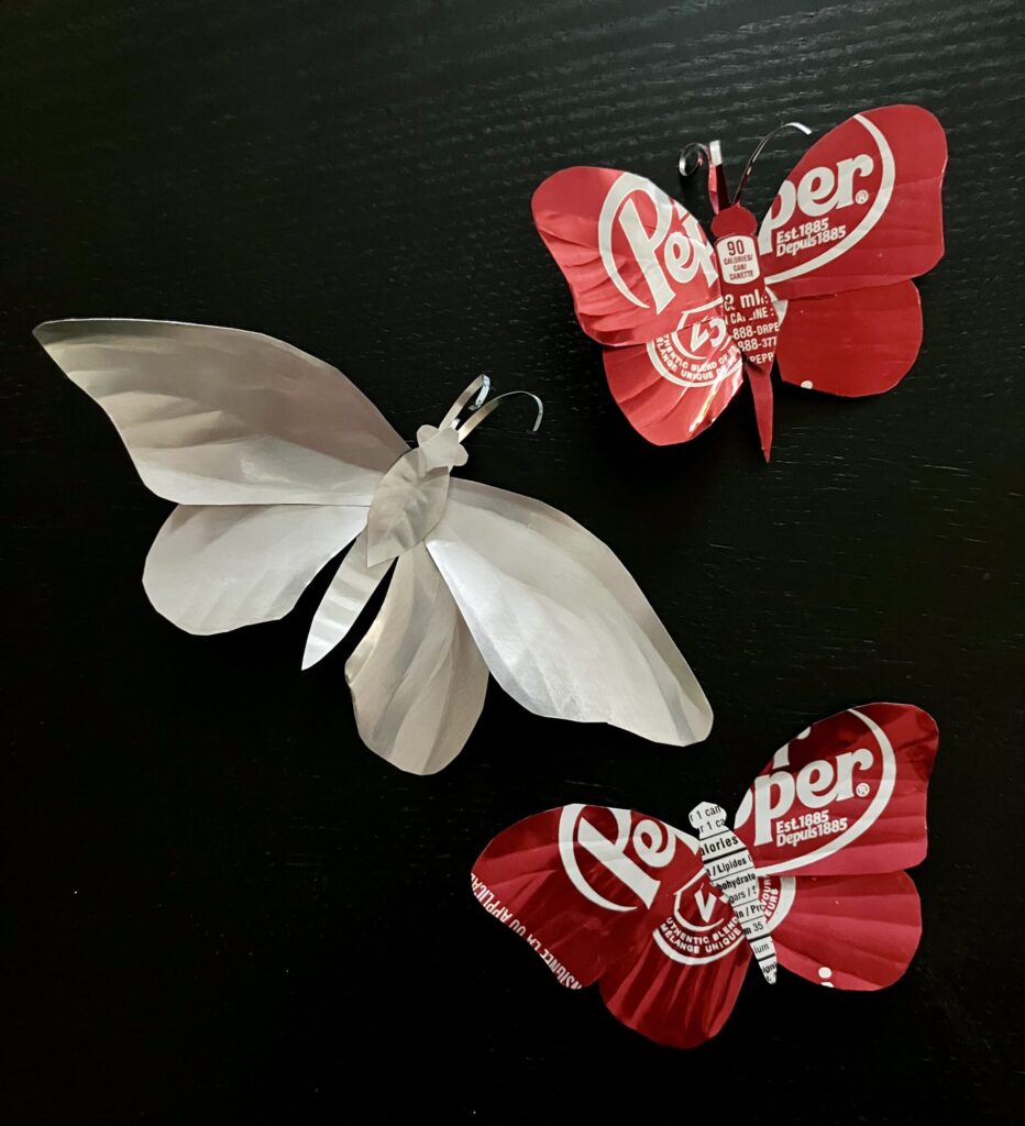 Three butterflies made of cut up soda cans.
