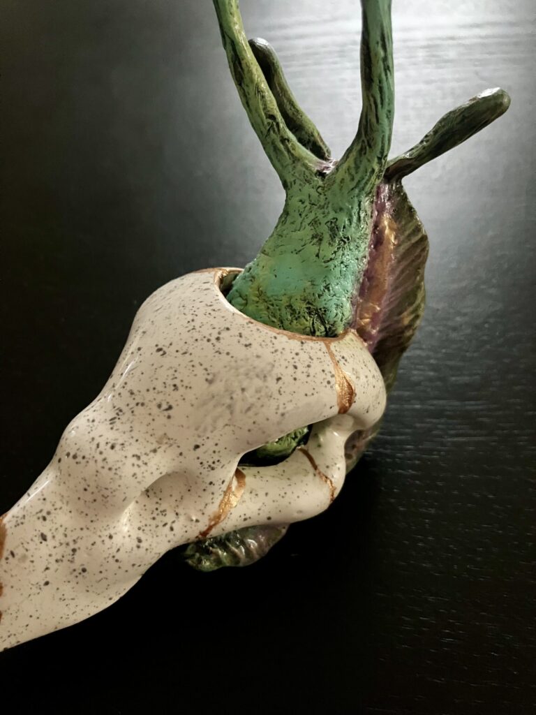 A sculpted snail with a bird skull for a shell.