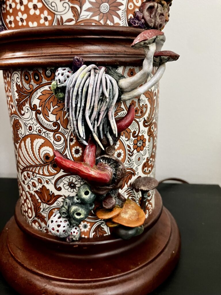 A close up photo of sculpted mushrooms on a lamp.