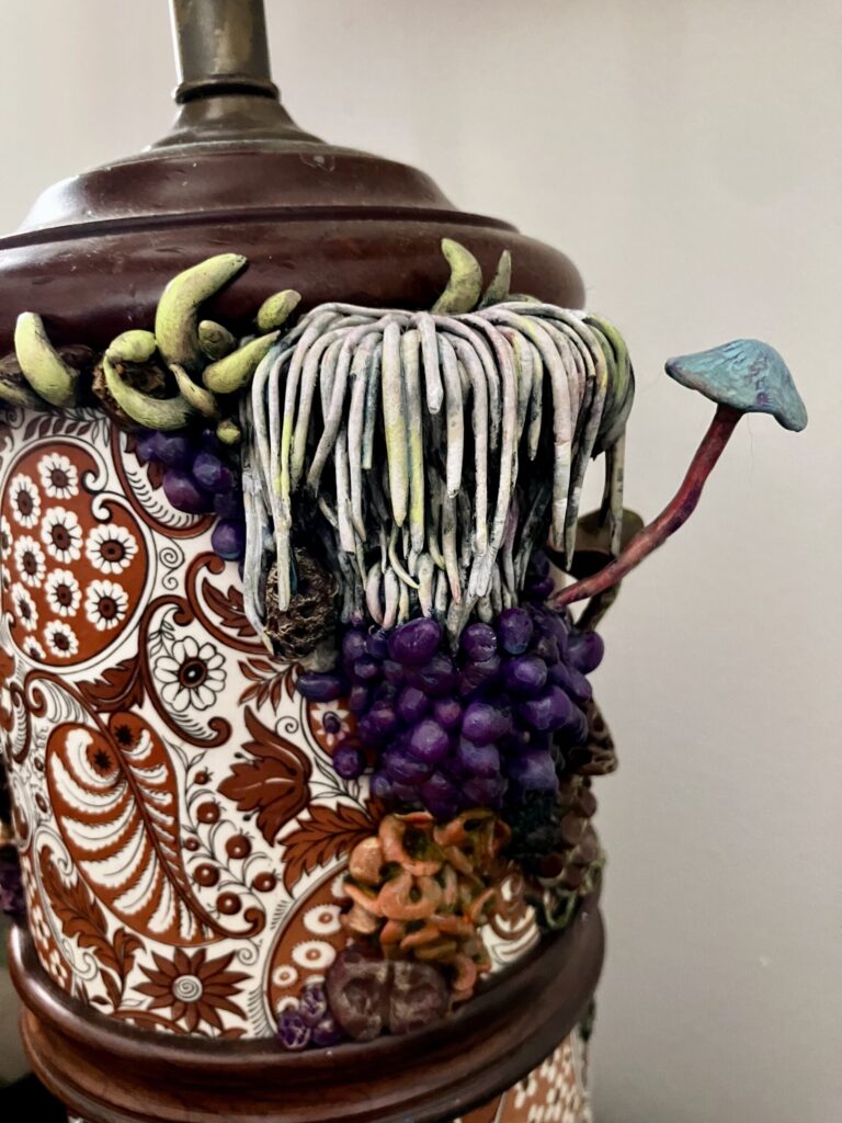 A close up photo of sculpted mushrooms on a lamp.