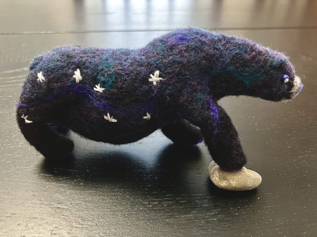 A needlefelted bear with stars on its side in the shape of the Big Dipper.