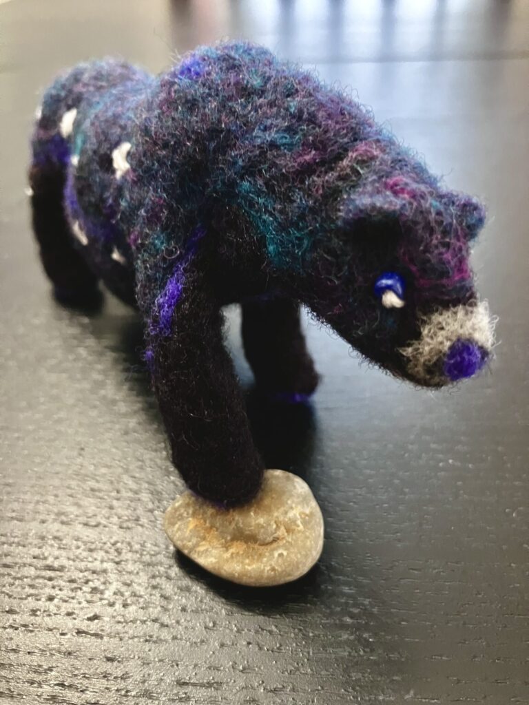 A needlefelted bear with stars on its side in the shape of the Big Dipper.