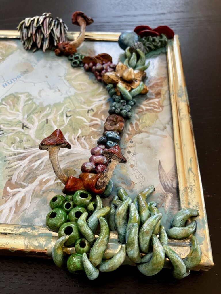 A close up photo of sculpted mushrooms on a framed map.