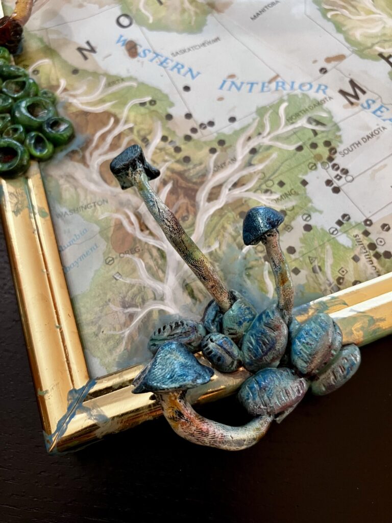 A close up photo of sculpted mushrooms on a framed map.