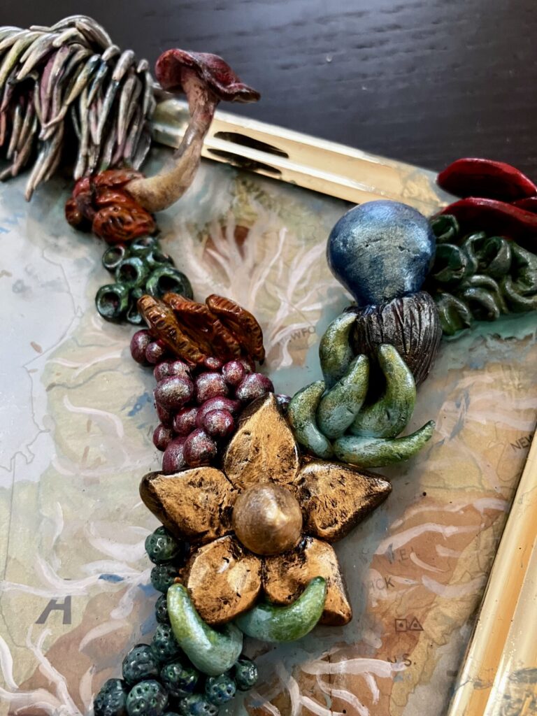 A close up photo of sculpted mushrooms on a framed map.